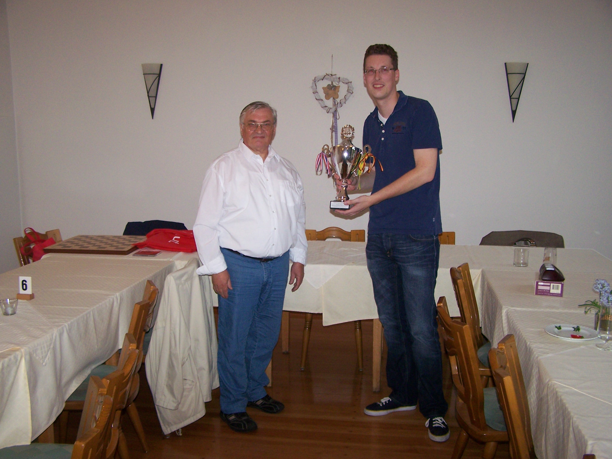 Organisator Udo Wickenfeld überreicht den Pokal zur Erinnerung an die Partnerschaft an Ben Sitton als Vertreter des Schaakclub Dordrecht